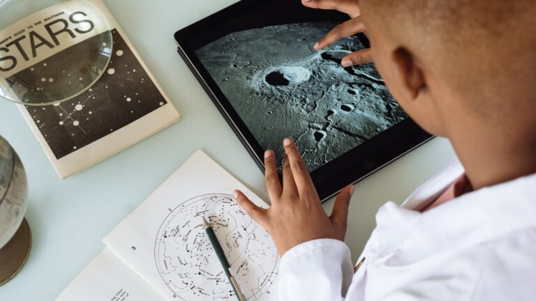 crop african american student studying craters of moon on tablet at observatory