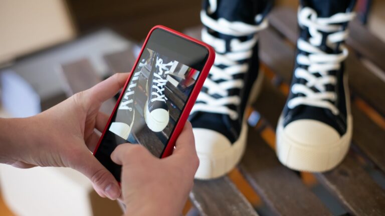 a person taking a photo of a pair of shoes