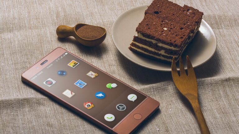 chocolate cake on saucer beside iphone