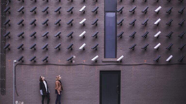 two person standing under lot of bullet cctv camera