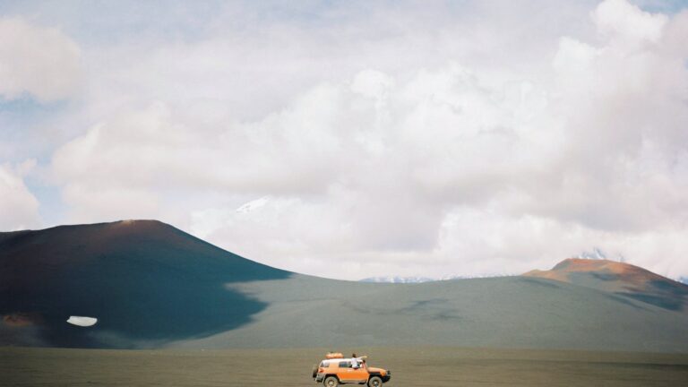 orange vehicle on brown sand